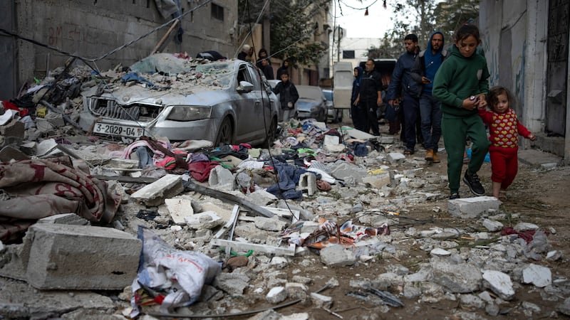 Palestinians look at the destruction after an Israeli airstrike in Rafah (Fatima Shbair/AP)