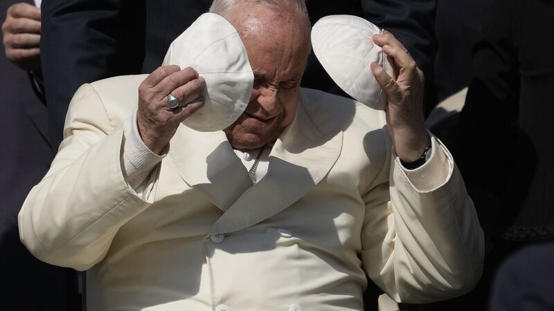 Pope Francis exchanges his skull cap with one given to him by a participant at last week's general audience in St Peter's Square at the Vatican. Picture by AP Photo/Alessandra Tarantino