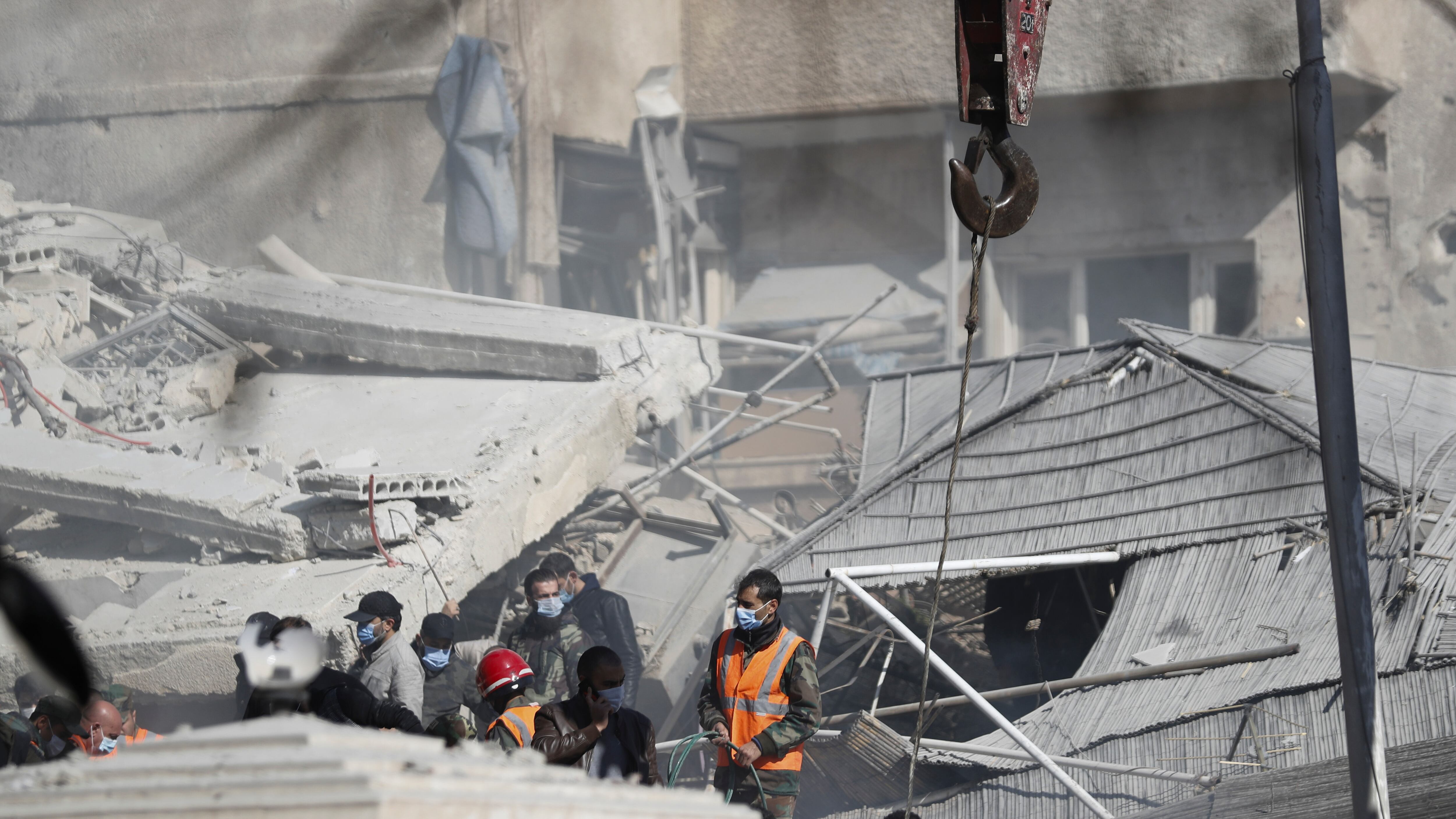 Emergency services work at a building hit by an air strike in Damascus, Syria, on Saturday (Omar Sanadiki/AP)