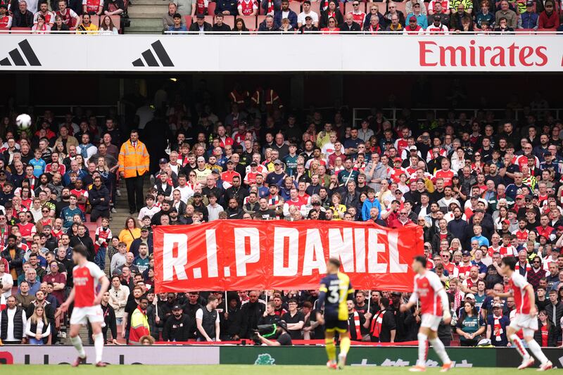 Arsenal fans hold up a banner