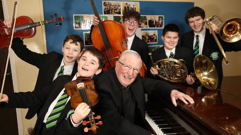 Fr Kevin McMullan pictured with St Malachy's pupils after returning to the school in 2018 to perform at an alumni recital.