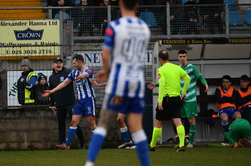 Newry City player Ciaran O'Connor is shown a red card following a foul on Cliftonville's Ronan Hale