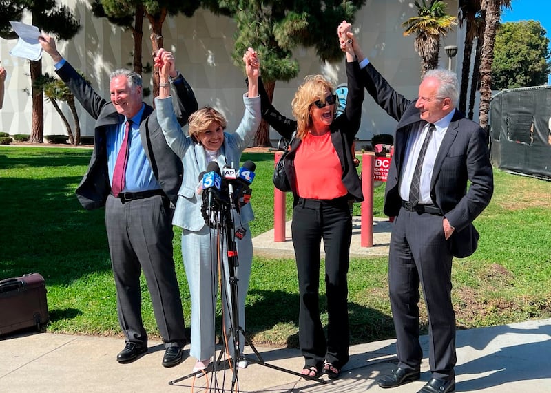 Attorneys John West, from left, Gloria Allred, plaintiff Judy Huth and attorney Nathan Goldberg join arms following a verdict in Huth’s favor in a civil trial involving actor Bill Cosby outside the Santa Monica Courthouse on Tuesday, March 21, 2022