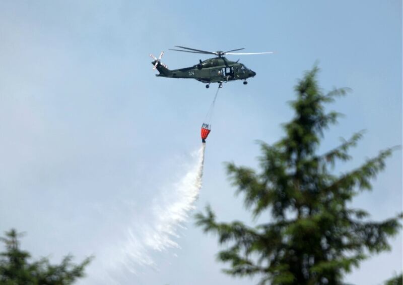 An Irish Air Corp helicopter drops water onto the huge gorse fire at Glenariff, Co Antrim, on Thursday. Picture by Mal McCann.
