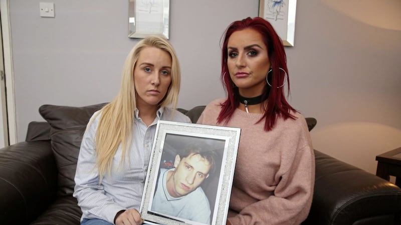 Eamonn Ferguson&#39;s sisters Lauren and Gail hold a photograph of their murdered brother. Picture by Mal McCann 