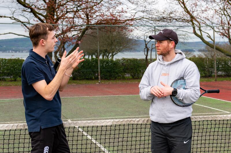 Peter Gault and Anthony Sinclair chatting on the tennis court