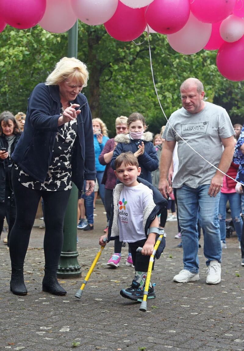 Tony Hudgell, who uses prosthetic legs, takes the final steps in his fundraising walk in West Malling, Kent, with mother Paula and father Mark