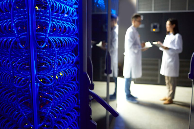 Two technicians stand near a supercomputer