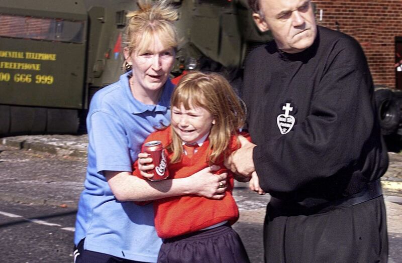 Fr Aidan Troy comforts a school girl and her mother during the Holy Cross disputes 20 years ago 
