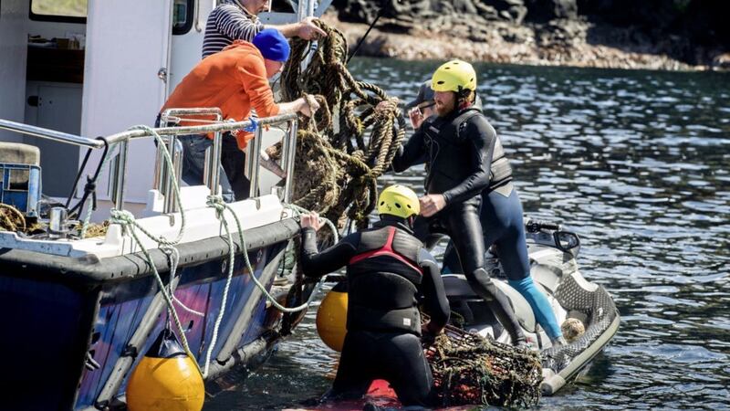 Volunteers load rubbish onto a boat during a litter pick around the coastline of the Giant&#39;s Causeway in Co Antrim Picture by Liam McBurney/PA 