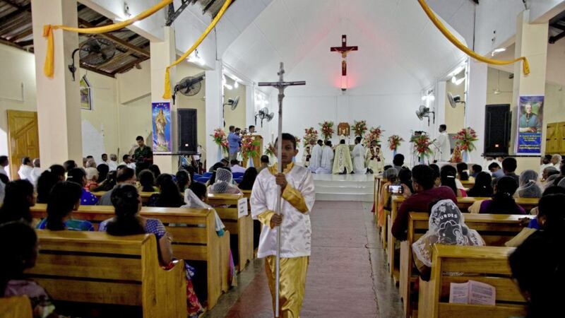 A boy holds a processional cross during Mass at St Joseph&#39;s church in Thannamunai, Sri Lanka. Picture by: Gemunu Amarasinghe/PA 