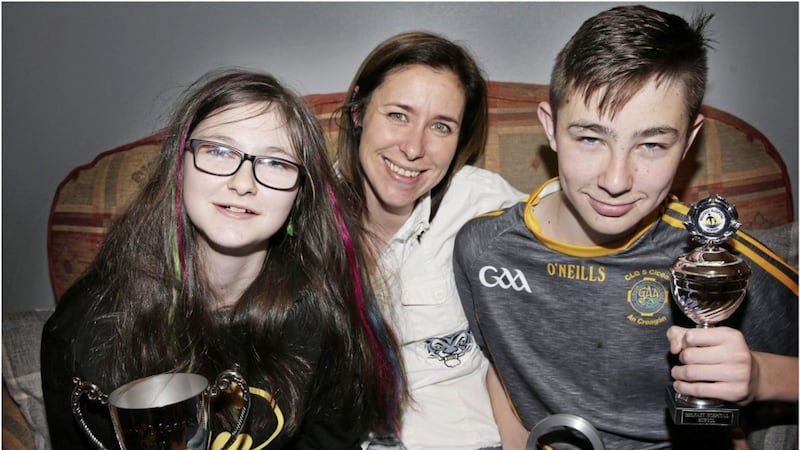Amelia O&#39;Neill with her children Mary and Fintan, a year after the pair suffered a catalogue of injuries when they were knocked down by a car getting off a school bus in Co Antrim. The siblings are pictured with awards they got from the Belfast Hospital School&#39;s annual prize giving event. Picture by Hugh Russell 