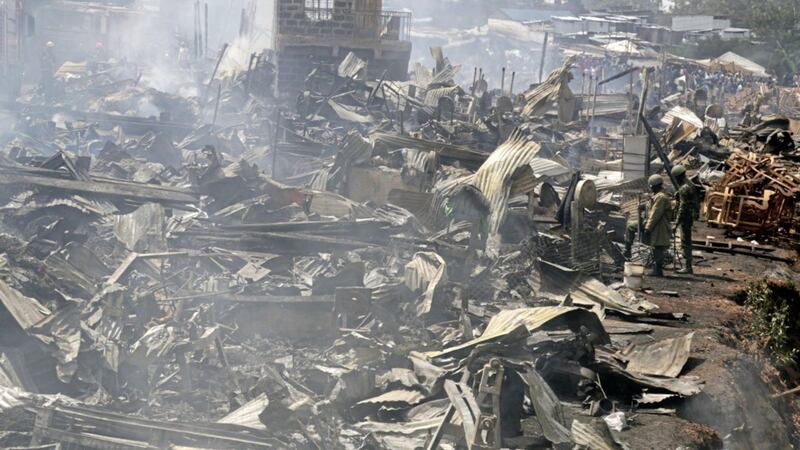 The remains of market stalls smoulder after a fire swept through the marketplace in Nairobi, Kenya Picture by Khalil Senosi/AP 