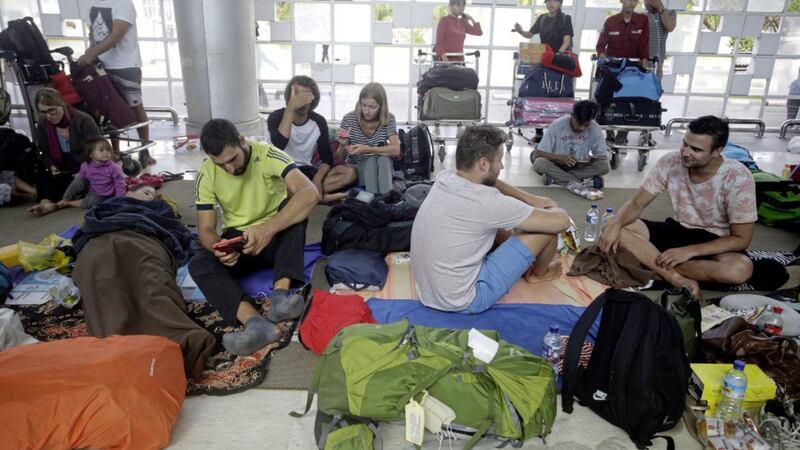 Tourists wait to get their airplane tickets at Lombok International Airport following an earthquake 