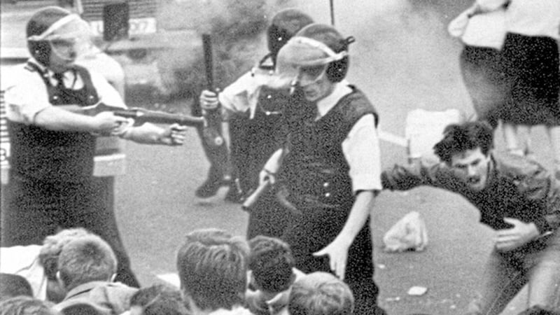 Sean Downes clutches his chest as he is struck by a plastic bullet in July 1984 