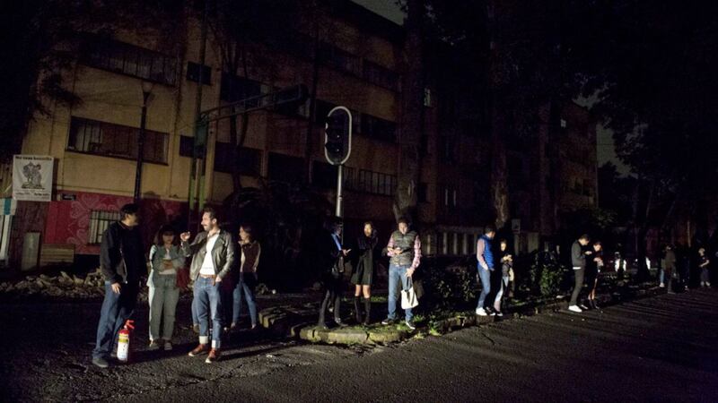 People who evacuated from bars during an earthquake stand in the street in La Roma neighborhood of Mexico City, sections of which lost power, on Thursday night. Picture by Rebecca Blackwell, Associated Press 