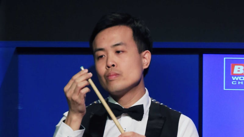 Marco Fu inspects his cue after the tip fell off during his match with Mark Selby on day 14 of the Betfred Snooker World Championships at the Crucible on Friday<br />Picture by PA&nbsp;