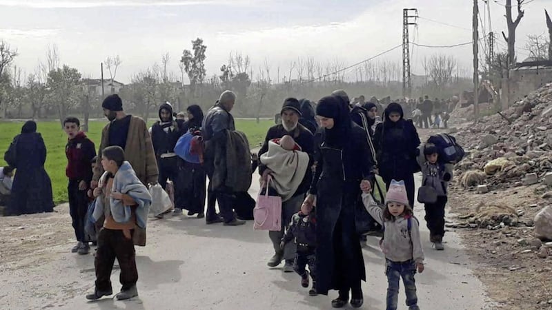 Syrian civilians with their belongings as they fleeing from fighting between the Syrian government forces and rebels, in Hamouria in eastern Ghouta Picture by SANA via AP 
