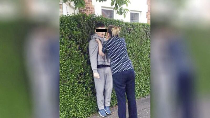 A woman confronts a youth after a car was broken into in west Belfast 