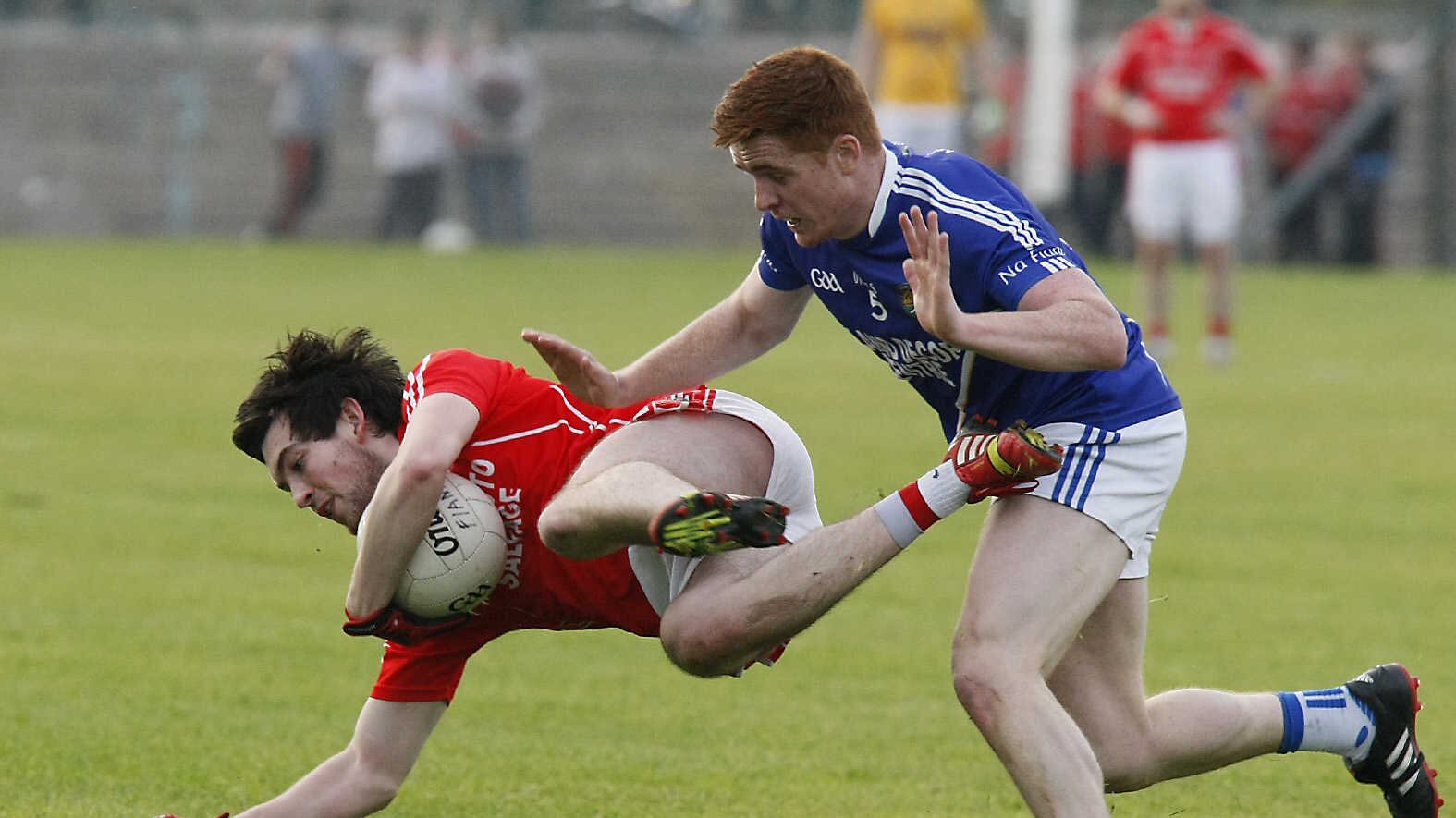 Trillick's Ruairí Kelly is sent flying by Coalisland's Jason Carberry during this year's Tyrone Senior Football Championship
