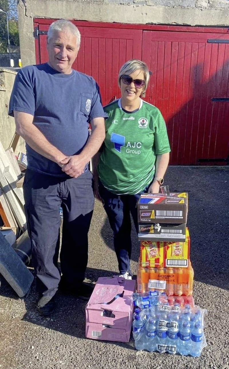 Edel Curran, chair of Russell Gaelic Union Downpatrick, hands over supplies for the firefighters tackling the fires in the Mourne Mountains to Damien Trainor, who&#39;s son, Damien is among those fire fighters 