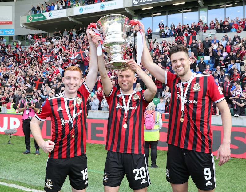 Crusaders players Jarlath O'Rourke, captain Philip Lowry, and striker Adam Lecky with the Irish Cup after thrashing Ballymena United 4-0. 