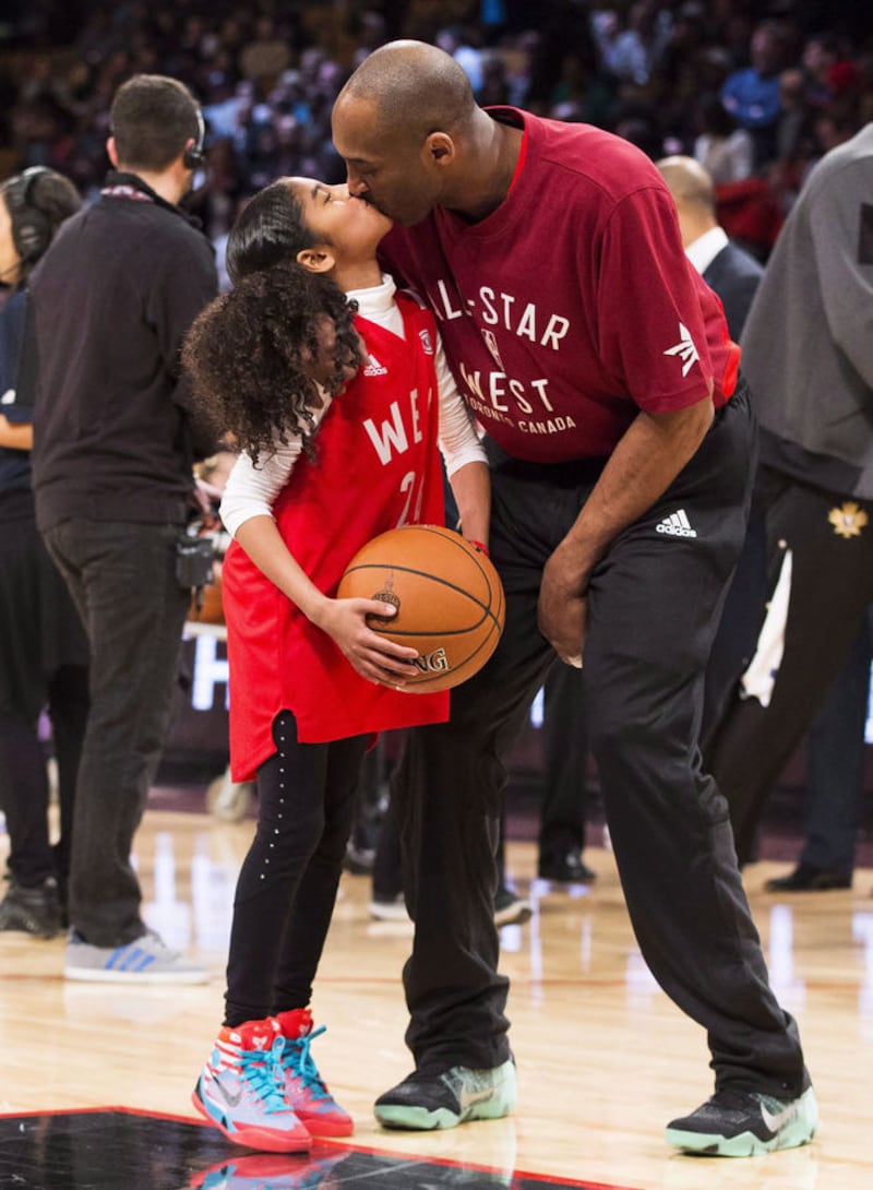 Basketball legend Kobe Bryant kisses his daughter Gianna before an NBA All-Star Game in Toronto in 2016. Bryant and 13-year-old Gianna were killed in a helicopter crash on Sunday along with seven others. Picture by The Canadian Press/Mark Blinch