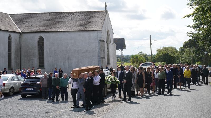 Mourners follow as Brendan Wall’s coffin is carried from church after his funeral (PA)