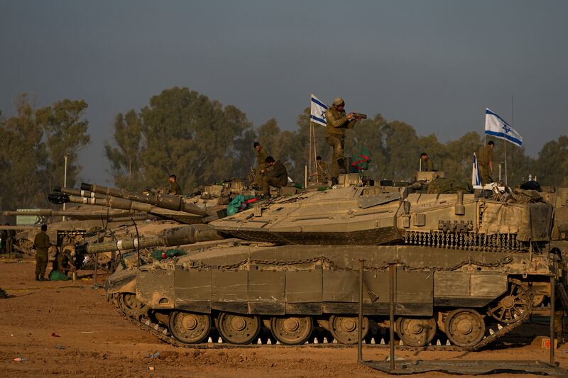 Israeli soldiers work on tanks (Ohad Zwigenberg/AP)