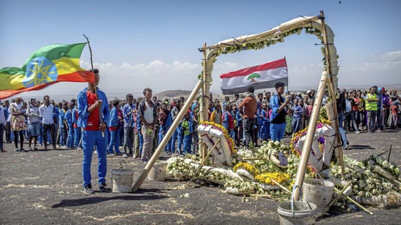 Students from Hama elementary school, who walked an hour and a half from their school in the surrounding area to pay their respects, stand next to floral tributes at the scene where the Ethiopian Airlines Boeing 737 Max 8 crashed shortly after takeoff last Sunday. Picture by Mulugeta Ayene, Associated Press 