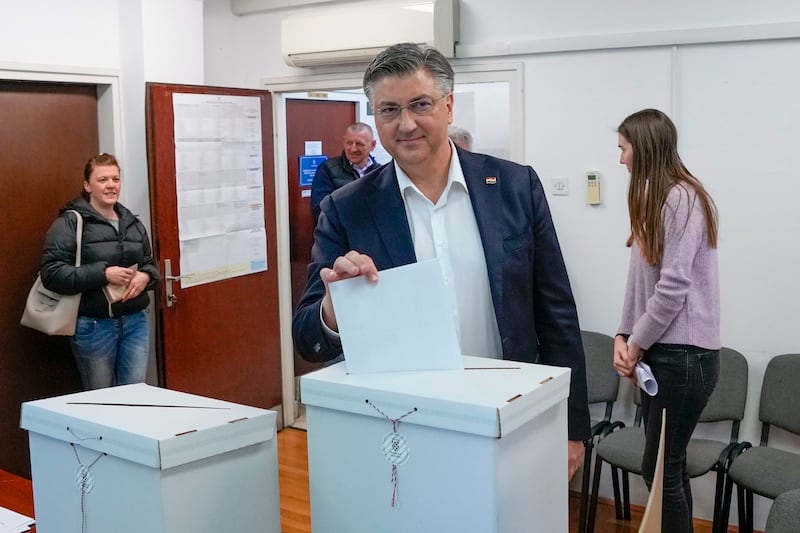 Prime Minister incumbent Andrej Plenkovic casts his ballot at a polling station in Zagreb (Darko Vojinovic/AP)