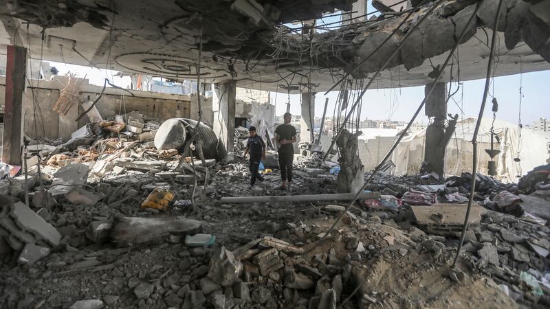 Palestinians stand in the ruins of a home after an overnight Israeli strike that killed at least two adults and five boys and girls under the age of 16 in Rafah, southern Gaza Strip (Ismael Abu Dayyah/AP)