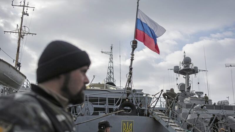 A Russian flag is raised aboard a Ukrainian navy ship that is next to the Ukrainian corvette Pridniprovya, right, in Sevastopol, Crimea on March 20 2014 