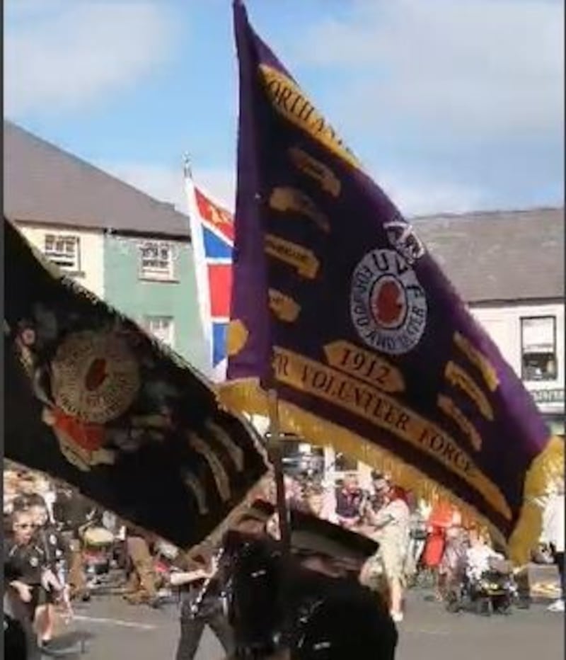 A flag bearing the letters UVF being carried by Silver Plains Flute Band