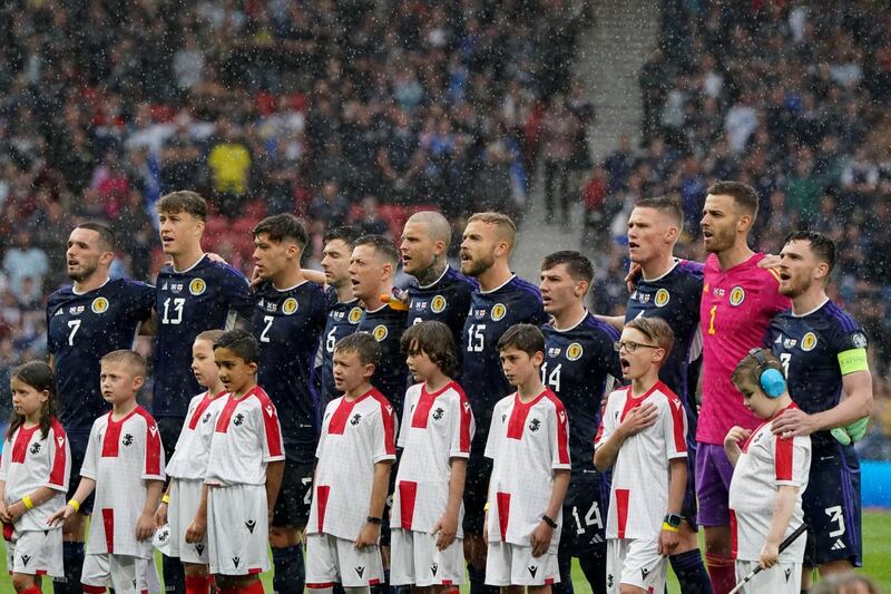 Scotland players sing the national anthem as heavy rain falls before kick-off 