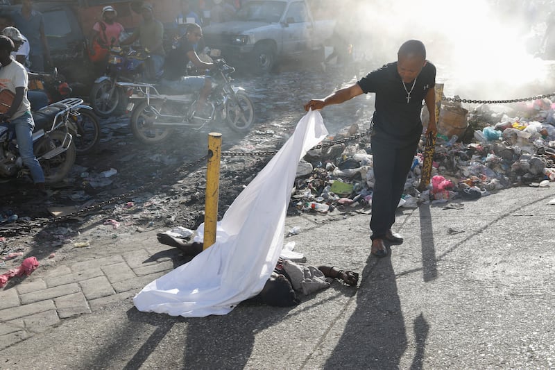 A body is cobvered by a sheet after an overnight shooting in the Petionville neighbourhood of Port-au-Prince, Haiti (Odelyn Joseph/AP)
