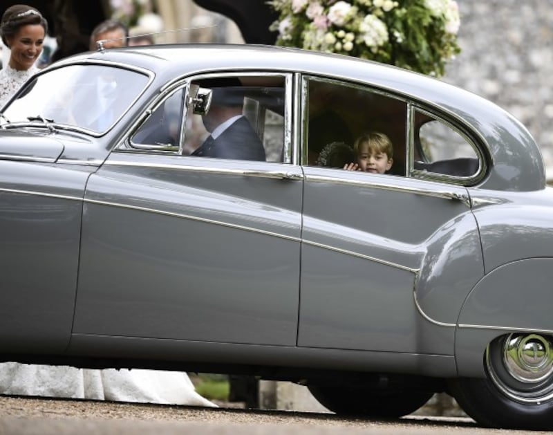 Britain's Prince George waves as he leaves in a car after attending the wedding of his aunt, Pippa…