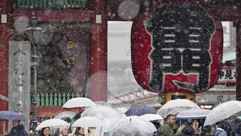 People visit Sensoji temple at the Asakusa district in Tokyo in snow on Monday (Kyodo News via AP)