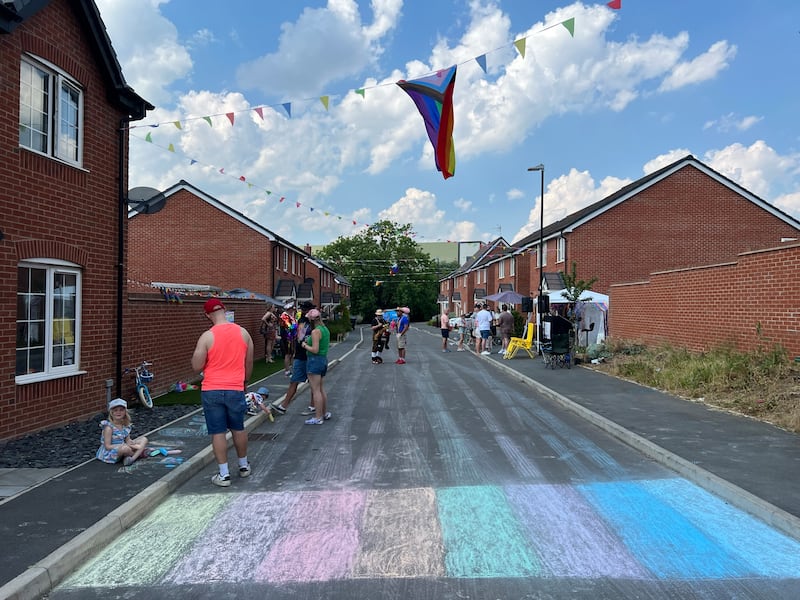 Batts Close in Rugby with the road painted in the colours of the Pride flag and rainbow bunting