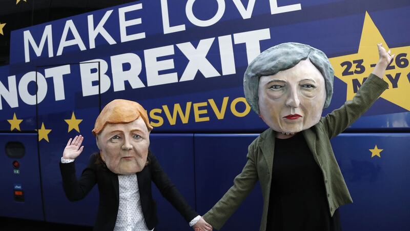 Activists pose with papier mache heads depicting British Prime Minister Theresa May, right, and German Chancellor Angela Merkel, left, during an anti-Brexit campaign stunt outside EU headquarters during an EU summit in Brussels, Thursday, March 21, 2019&nbsp;