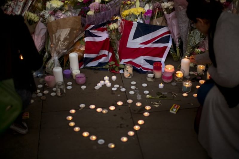 A British flag is seen next to flowers after a vigil in Albert Square