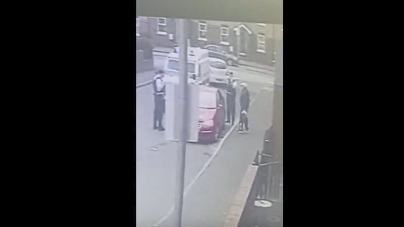 Camera footage show PSNI officers standing at a car driven by IRSP member James McElkerney 