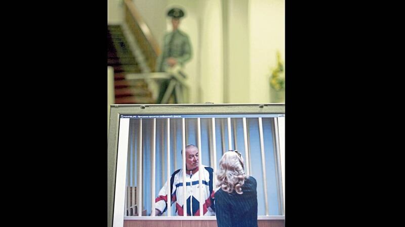 Sergei Skripal speaks to his lawyer in 2006 from behind bars seen on a screen of a monitor outside a courtroom in Moscow 