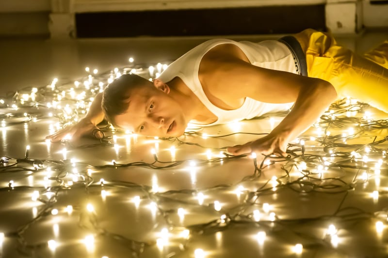 Man lying on the floor, which has lights on it 