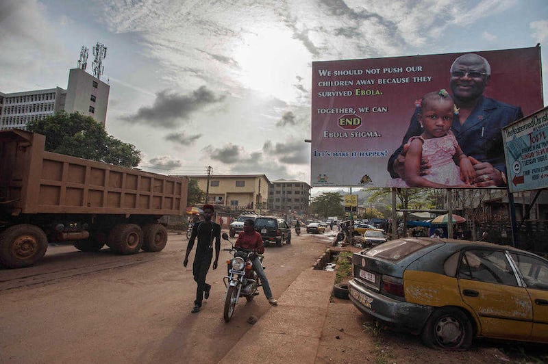 A man walks past a poster reading &#39;We should not push our children away because they survived Ebola&#39; &ndash; part of Sierra Leone&#39;s Ebola campaign in the city of Freetown 