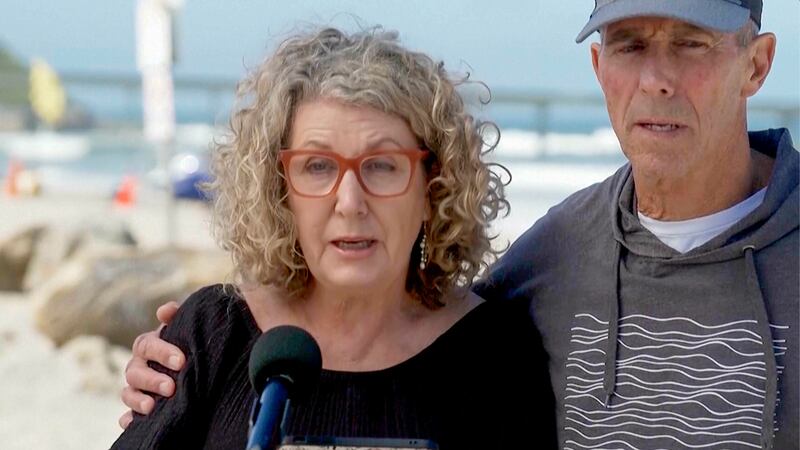 In this image taken from video, Australia’s Debra Robinson with her husband Martin, address the media on the beach in San Diego (Channel 9/POOL via AP)