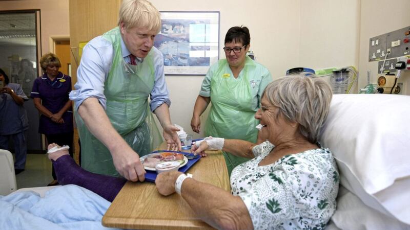 Prime Minister Boris Johnson serves food to Wenona Pappin (70) during a visit to Torbay Hospital in Devon on Friday. Picture by Finnbarr Webster, Press Association 
