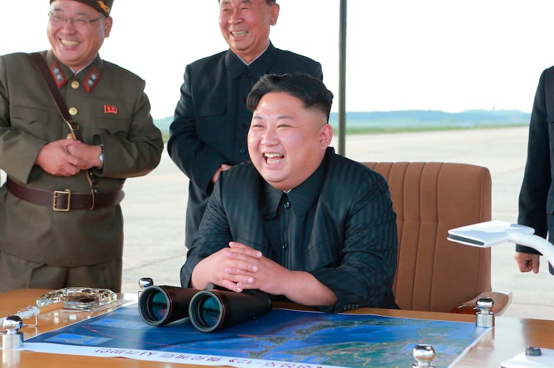 Kim Jong Un laughs at what the North Korean government said was a missile test
