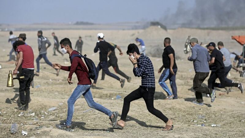 Palestinian protesters run for cover during a protest at the Gaza Strip&#39;s border with Israel last week. Israeli troops fired from across a border fence, killing dozens of Palestinians and wounded more than 2,700 at a mass protest in Gaza. Picture by AP Photo/Khalil Hamra 