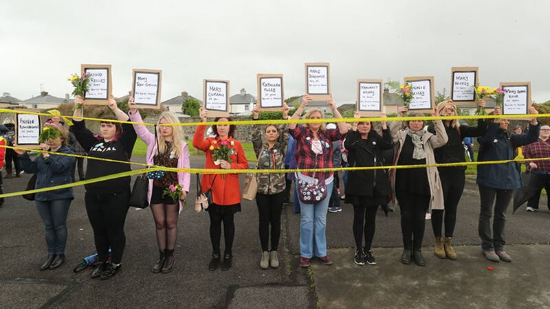 People hold up names of children as they gather to protest at the site of the former Tuam home for unmarried mothers in County Galway&nbsp;